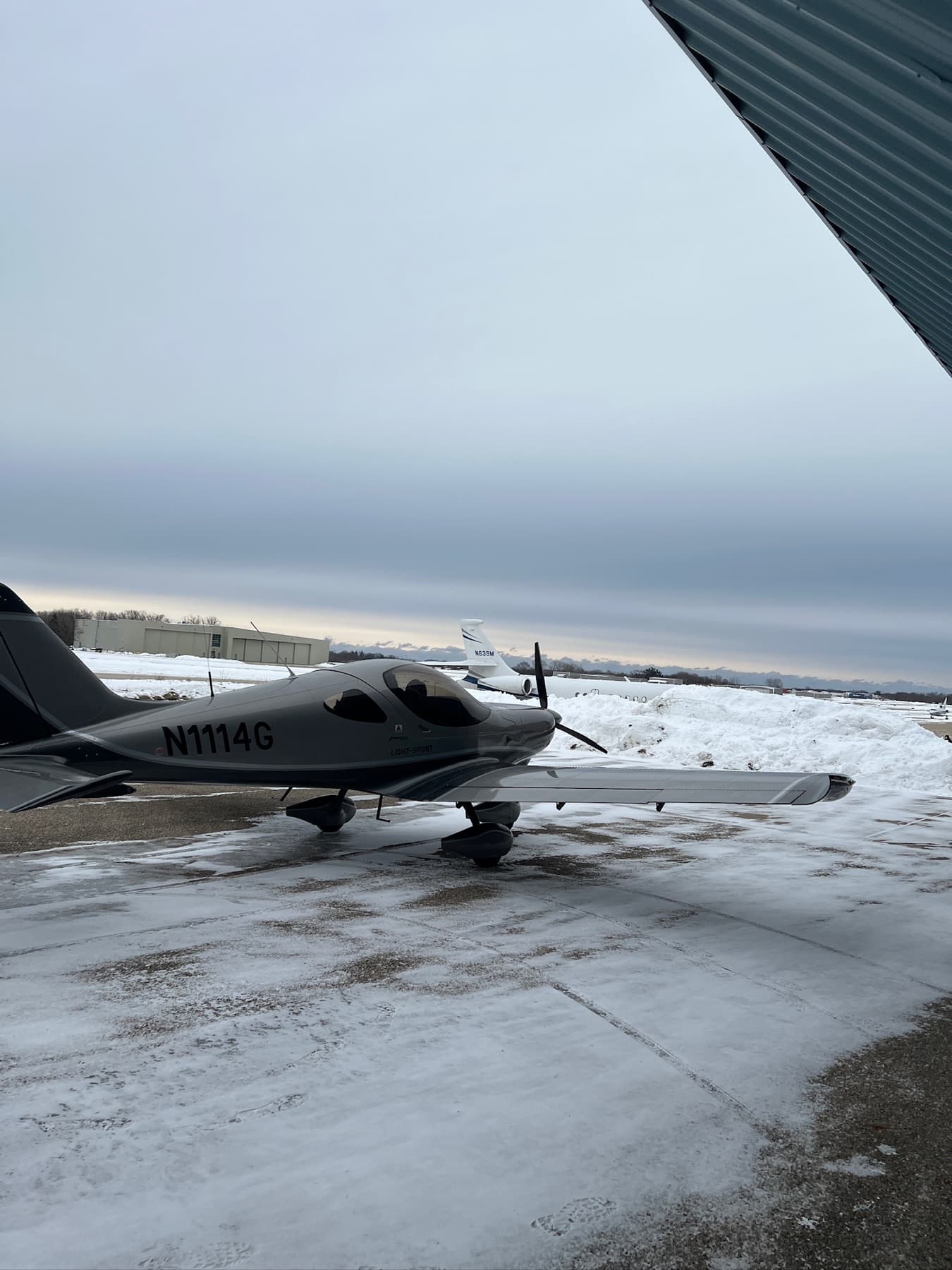 A silver Bristell on the ramp in low winter light