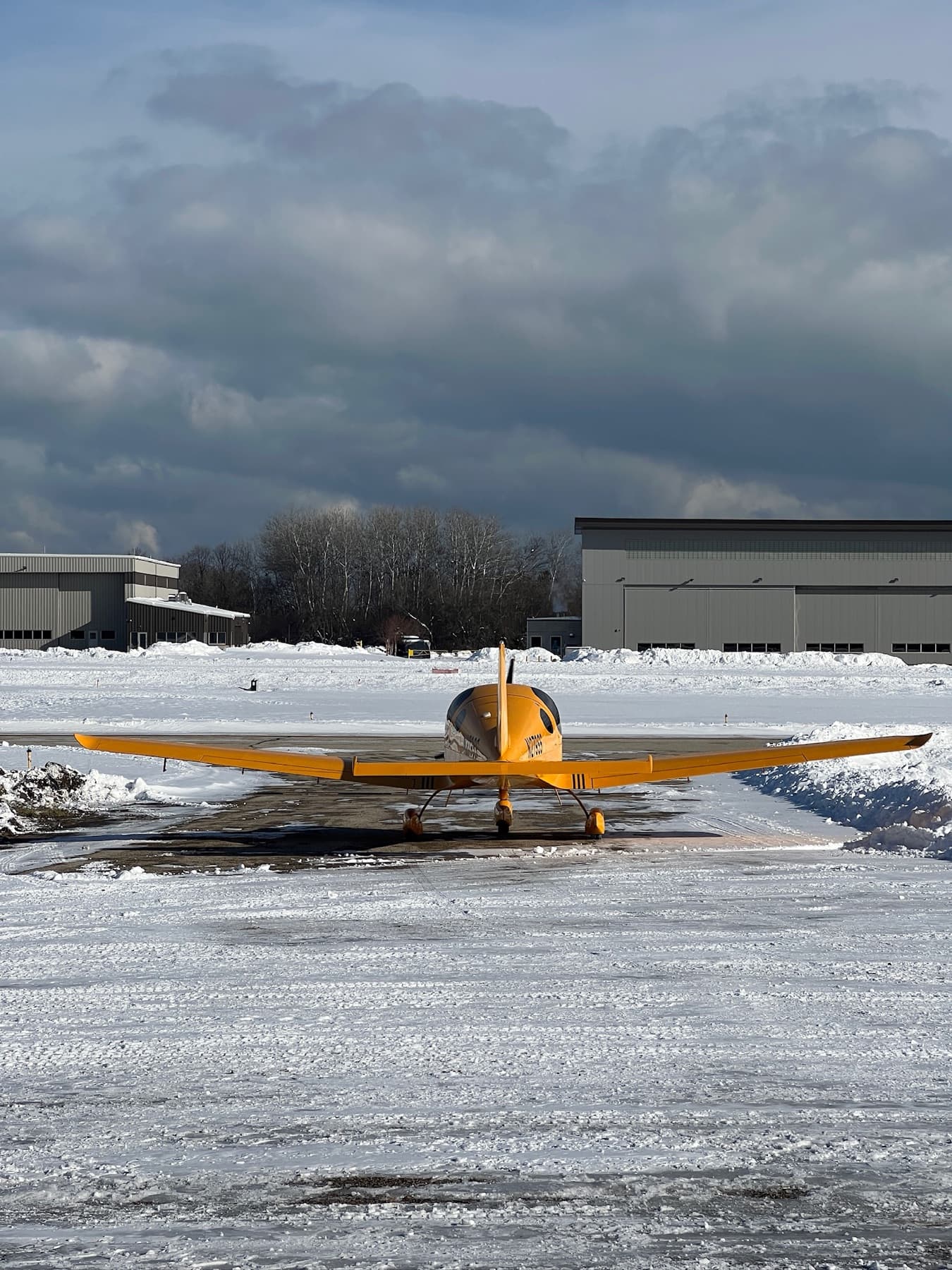 A yellow Bristell head on across a snow covered ramp