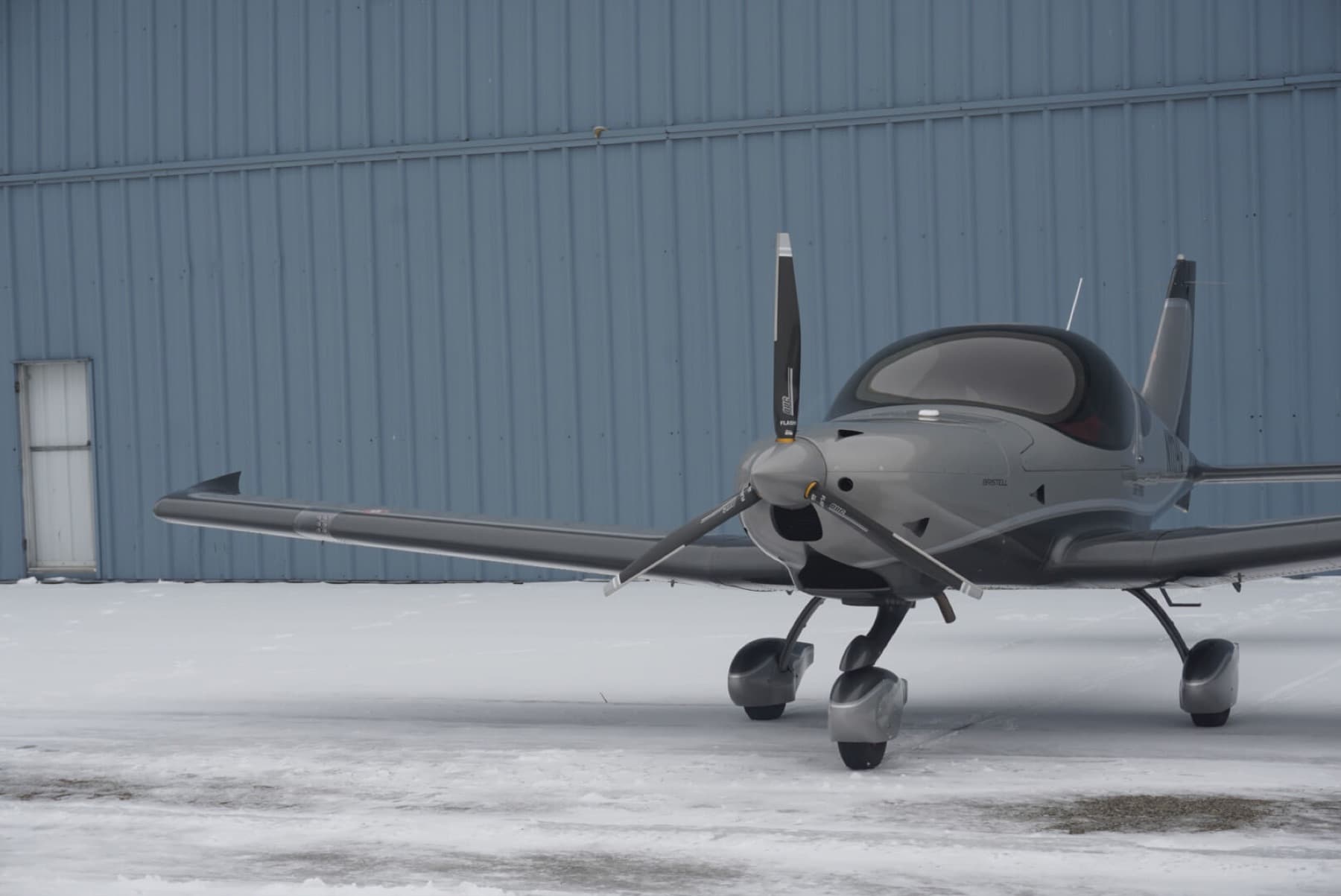 A Bristell parked on a snow-covered ramp