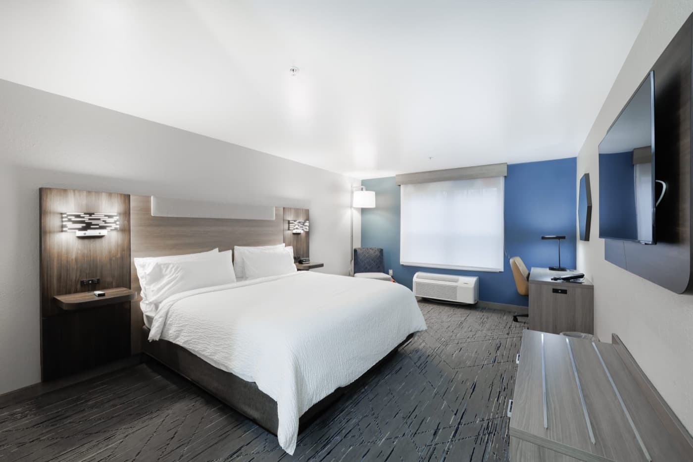 Hotel room with a king bed, desk and window