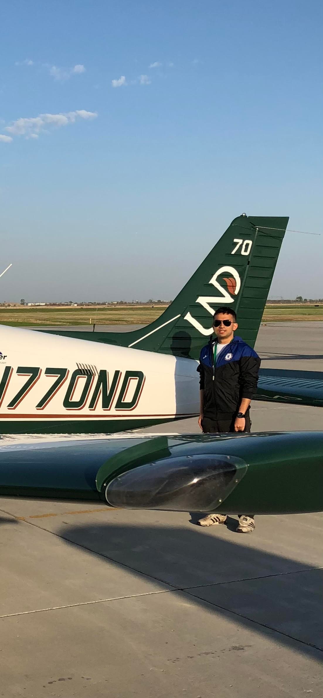 Raf on the ramp beside a green-and-white training aircraft