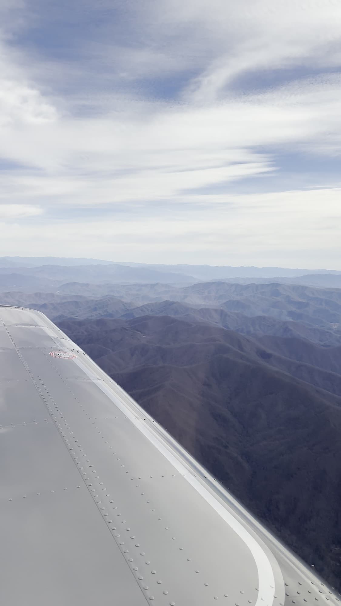 View over the wing across mountain ridges in flight